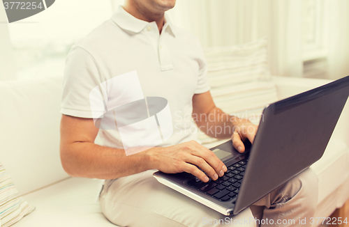 Image of close up of man working with laptop at home