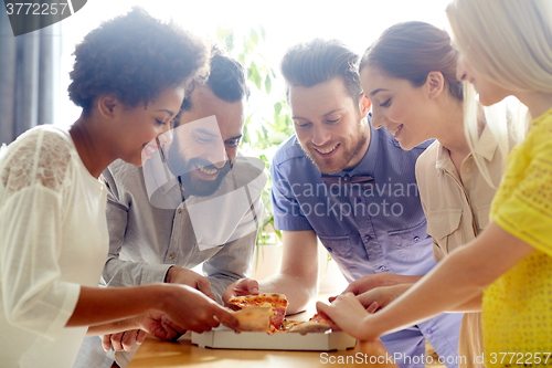 Image of happy business team eating pizza in office