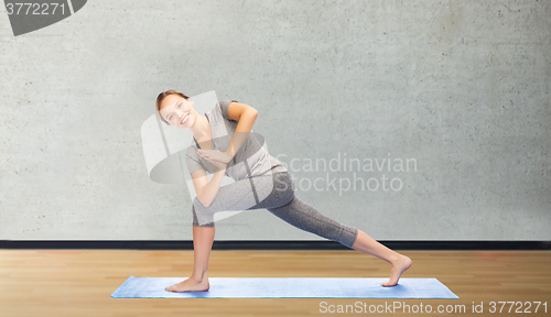 Image of woman making yoga low angle lunge pose on mat