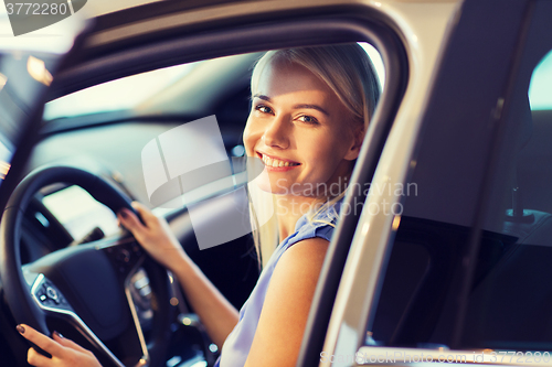 Image of happy woman inside car in auto show or salon