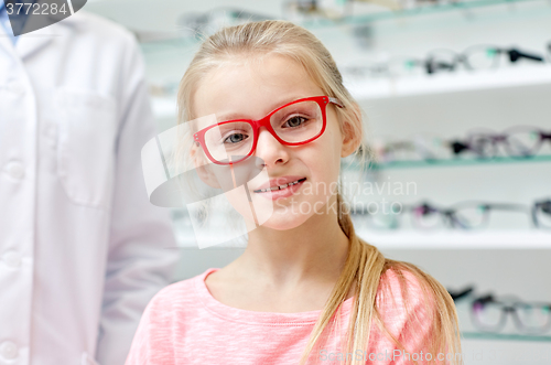 Image of girl in glasses with optician at optics store