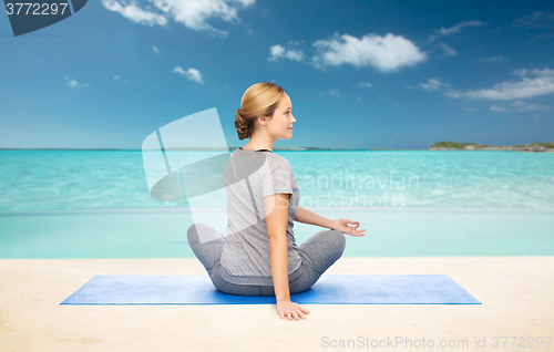 Image of woman making yoga in twist pose on mat