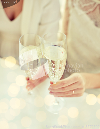 Image of close up of lesbian couple with champagne glasses