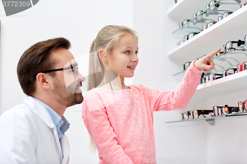 Image of optician and girl choosing glasses at optics store