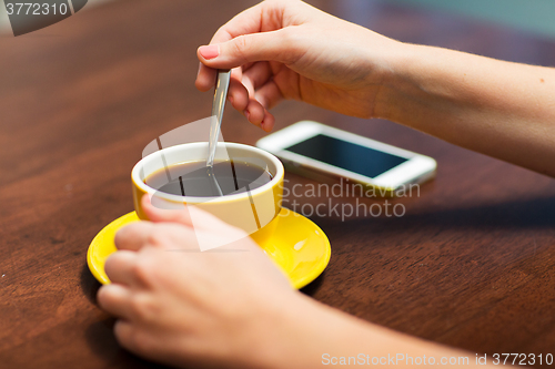 Image of close up of woman with smartphone and coffee