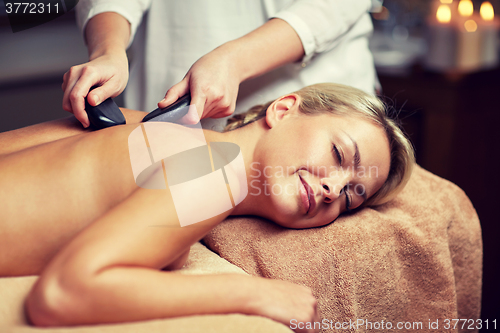 Image of close up of woman having hot stone massage in spa