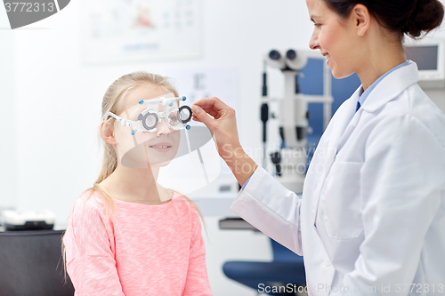 Image of optician with trial frame and girl at clinic
