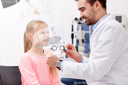 Image of optician with trial frame and girl at clinic