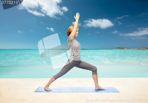 Image of woman making yoga warrior pose on mat