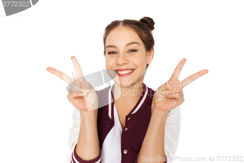 Image of happy smiling teenage girl showing peace sign