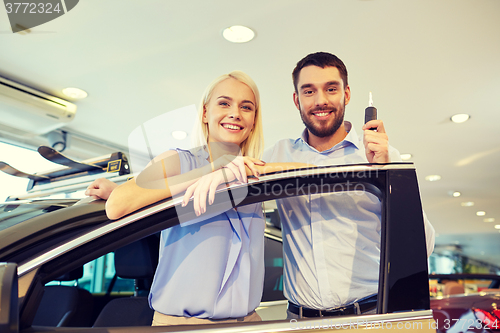 Image of happy couple buying car in auto show or salon