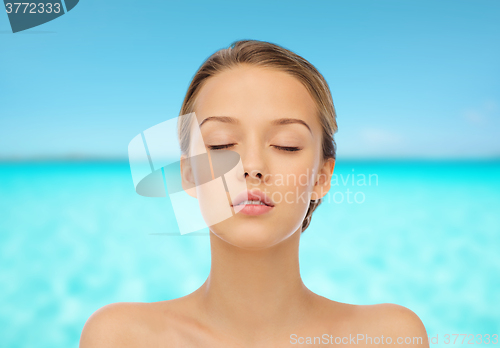 Image of young woman face over blue sea nd sky