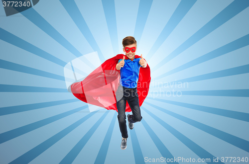 Image of boy in super hero cape and mask showing thumbs up