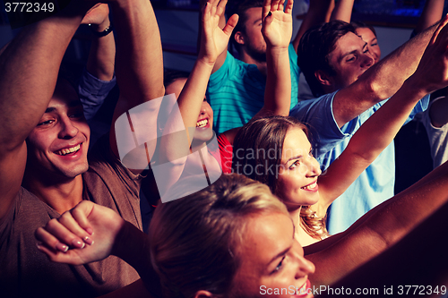 Image of group of smiling friends at concert in club