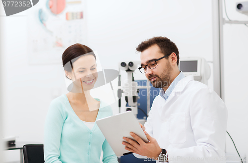 Image of optician with tablet pc and patient at eye clinic