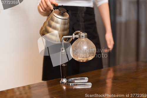 Image of close up of woman with siphon coffee maker and pot