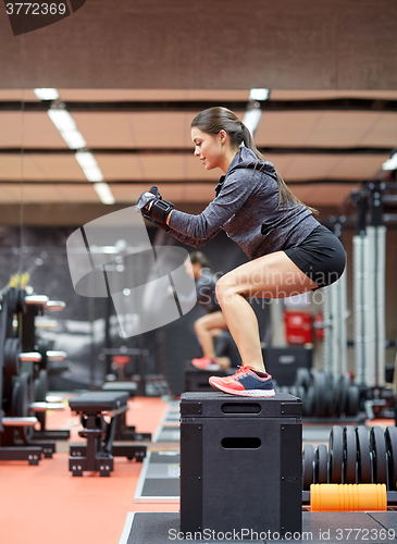 Image of woman doing squats on pnatfom in gym