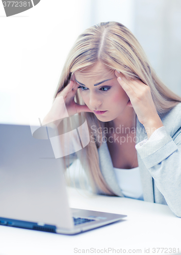 Image of stressed woman with laptop