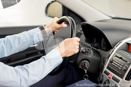 Image of close up of young man driving car