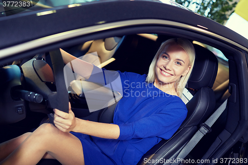 Image of happy woman inside car in auto show or salon