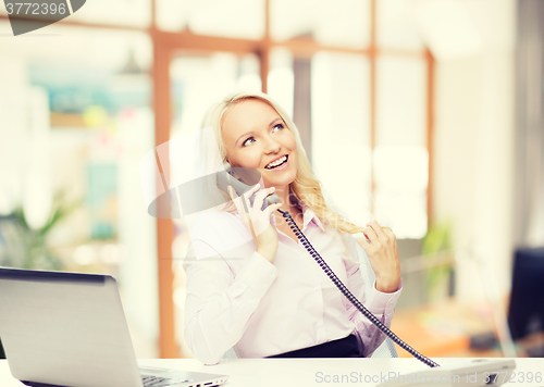 Image of smiling businesswoman or student calling on phone