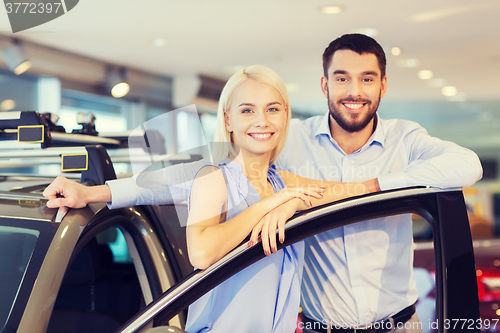 Image of happy couple buying car in auto show or salon