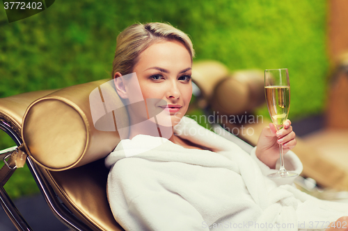 Image of beautiful young woman drinking champagne at spa