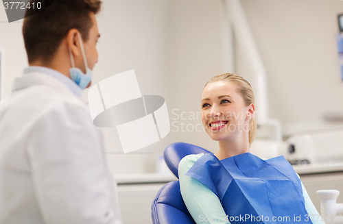 Image of happy male dentist with woman patient at clinic
