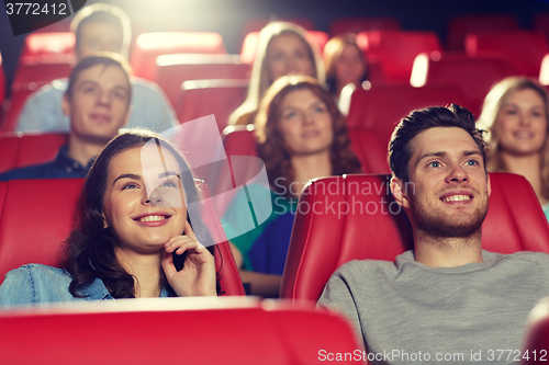 Image of happy friends watching movie in theater