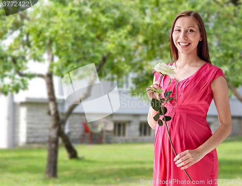 Image of happy pregnant woman with rose flower