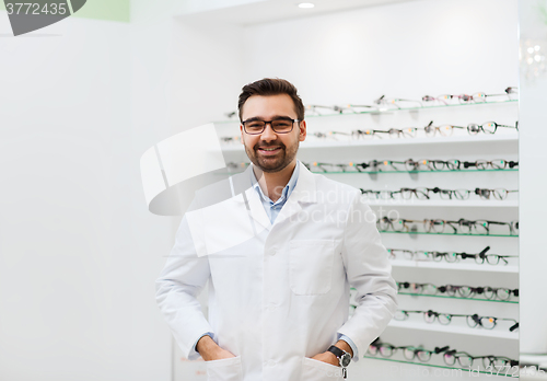 Image of man optician in glasses and coat at optics store