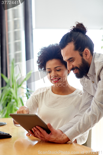 Image of happy creative team with tablet pc in office