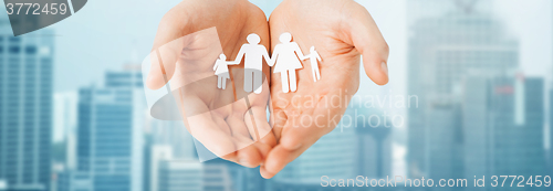 Image of man hands holding paper cutout of family