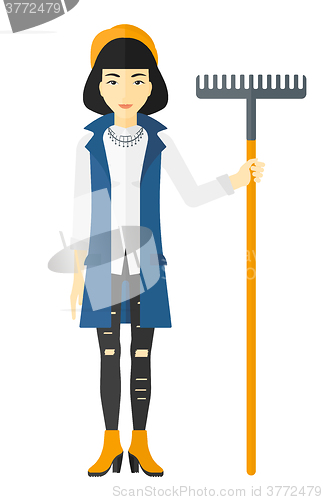 Image of Woman standing with rake.