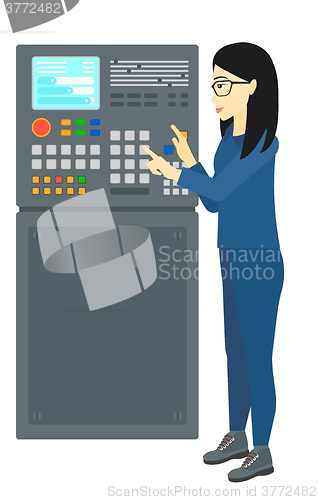 Image of Engineer standing near control panel.