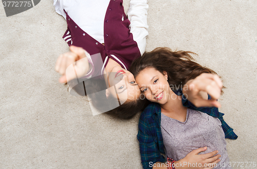 Image of smiling teenage girls pointing finger to you
