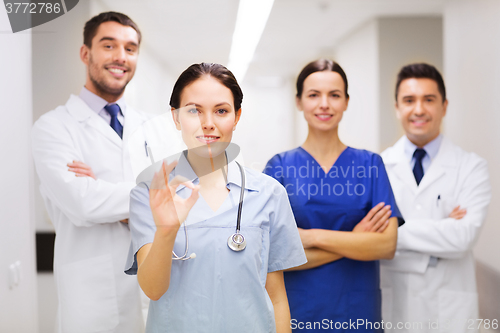 Image of group of medics at hospital showing ok hand sign