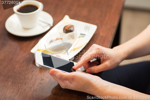 Image of close up of woman with smartphone and dessert
