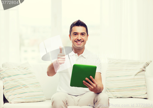 Image of smiling man working with tablet pc at home