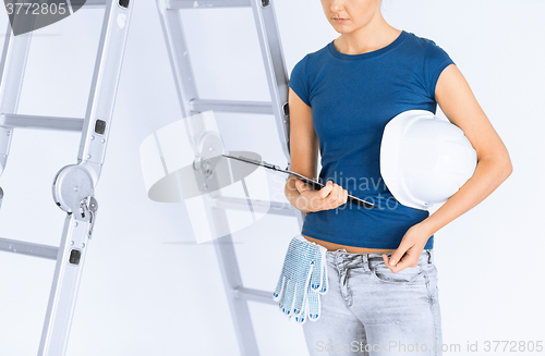 Image of woman architect with helmet and blueprint