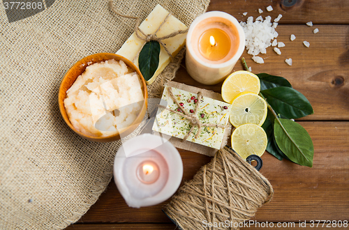 Image of close up of natural soap and candles on wood