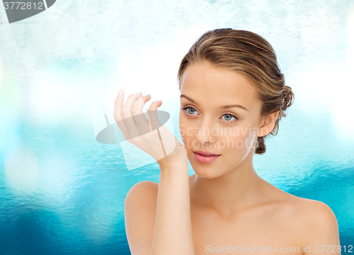 Image of woman smelling perfume from wrist of her hand