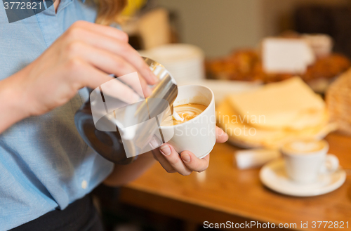 Image of close up of woman making coffee at shop or cafe