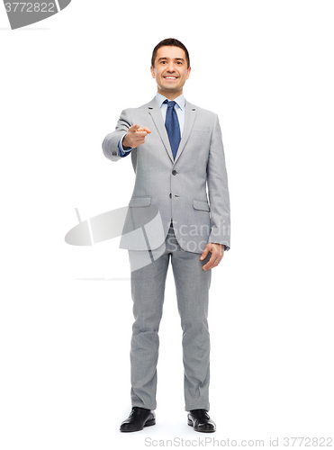 Image of happy smiling businessman in suit pointing at you