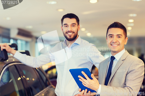 Image of happy man with car dealer in auto show or salon