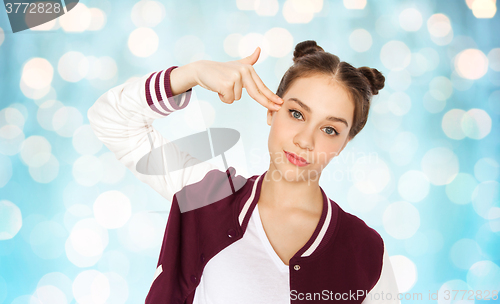 Image of bored teenage girl making finger gun gesture