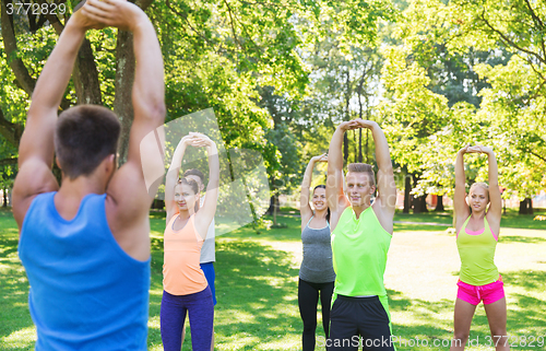 Image of group of friends or sportsmen exercising outdoors