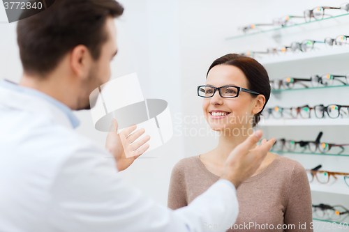 Image of optician and woman in glasses at optics store