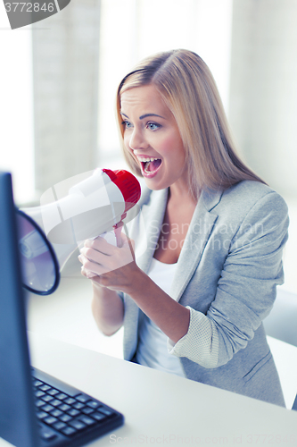 Image of crazy businesswoman shouting in megaphone