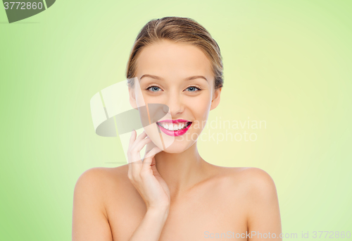 Image of smiling young woman with pink lipstick on lips